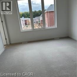A room with a window showing a view of a building and trees.