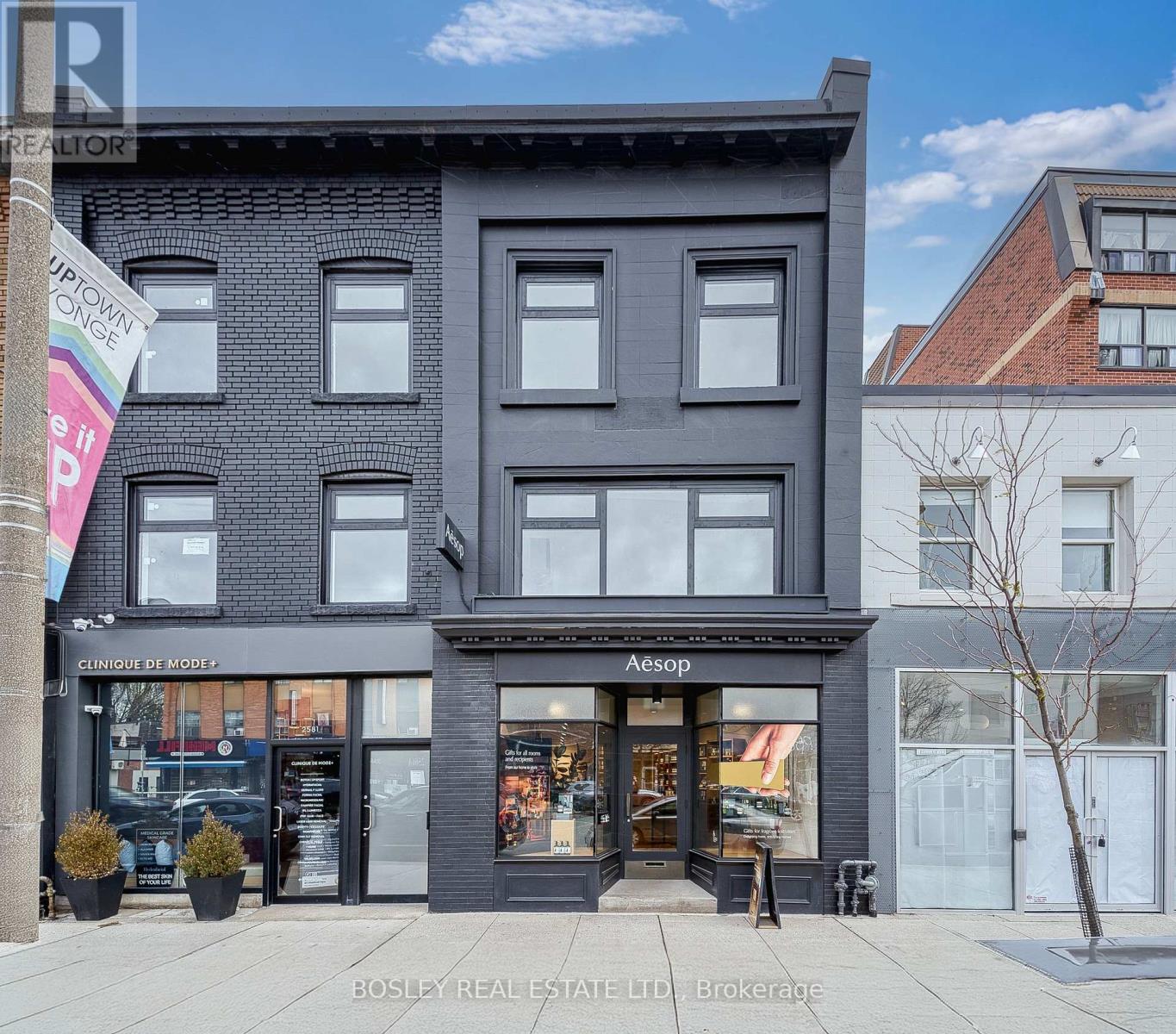 A black building with a storefront on the ground floor.