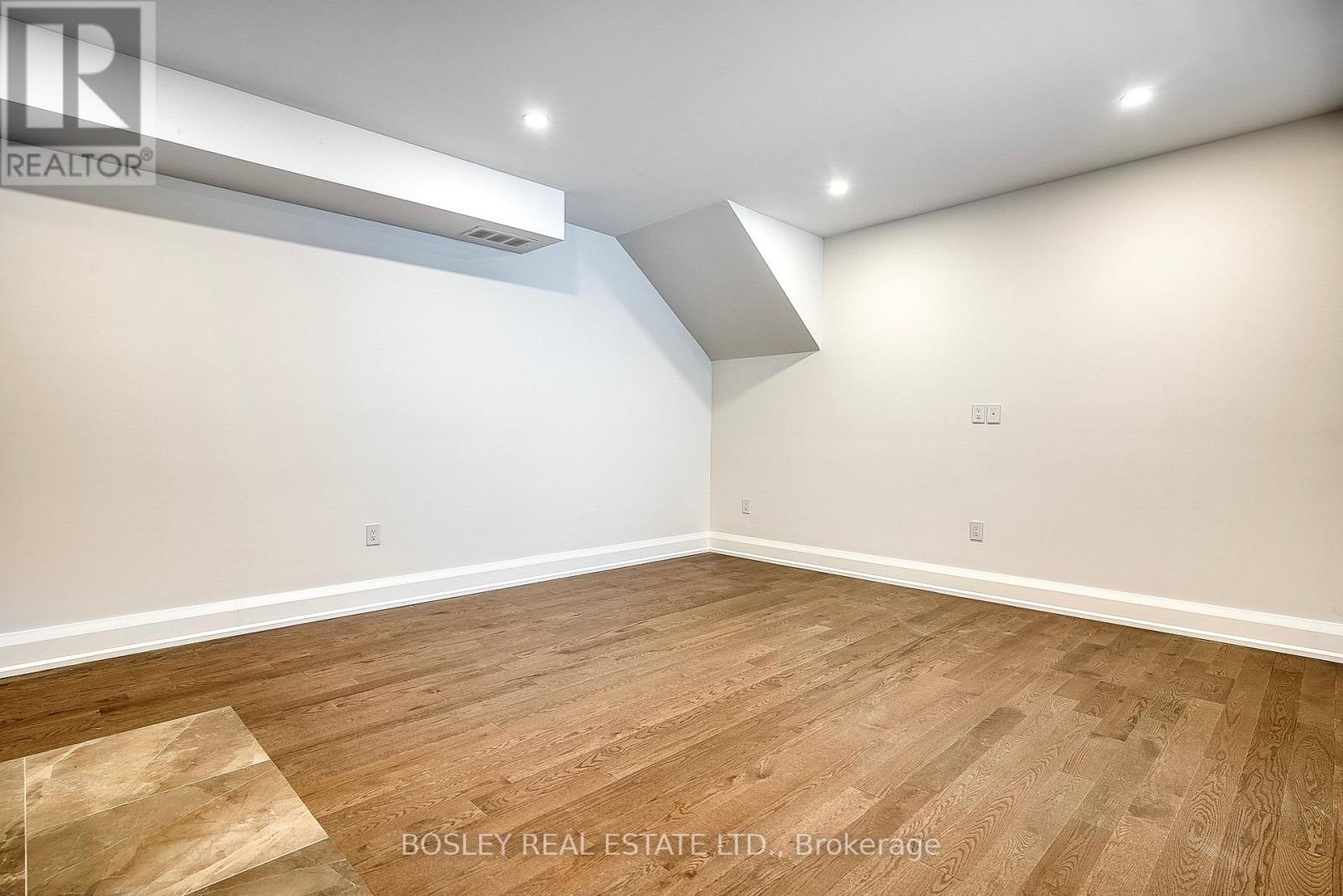 A room with wooden flooring and a white ceiling with a light fixture.