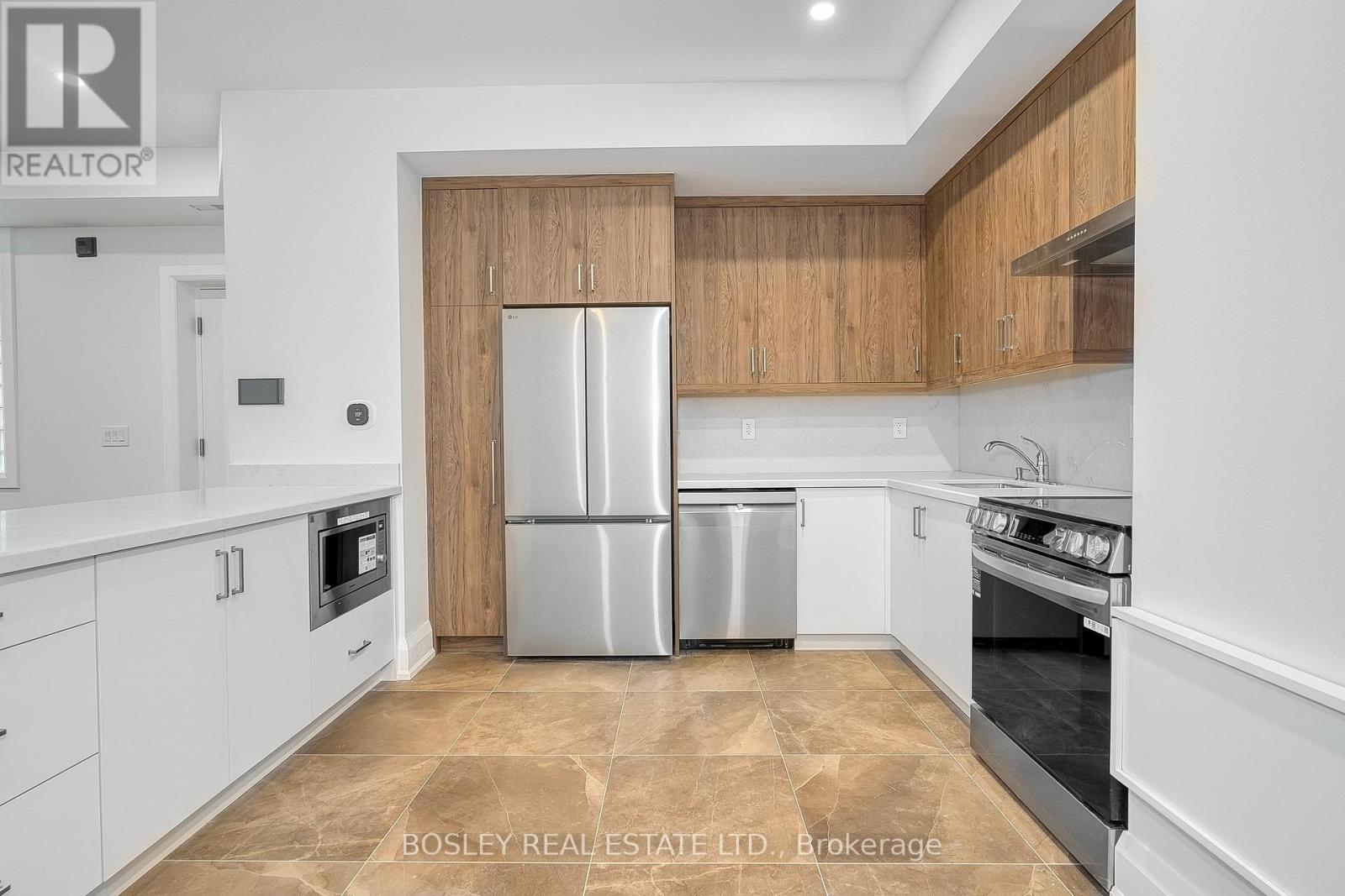 A kitchen with a refrigerator, oven, and dishwasher.