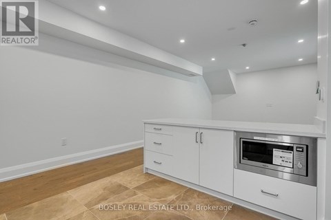 A kitchen with white cabinets and a microwave oven.