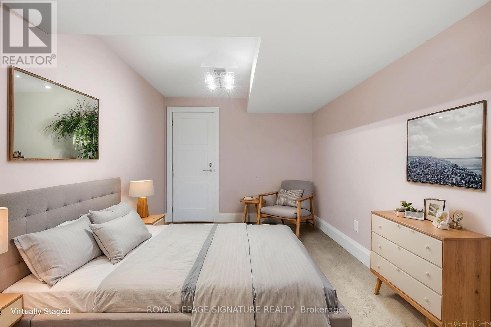 A bedroom with a bed, nightstand, and chair.