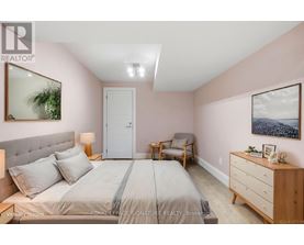 A bedroom with a bed, nightstand, and chair.