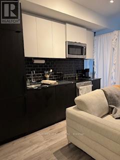 A black and white kitchen with a white couch.