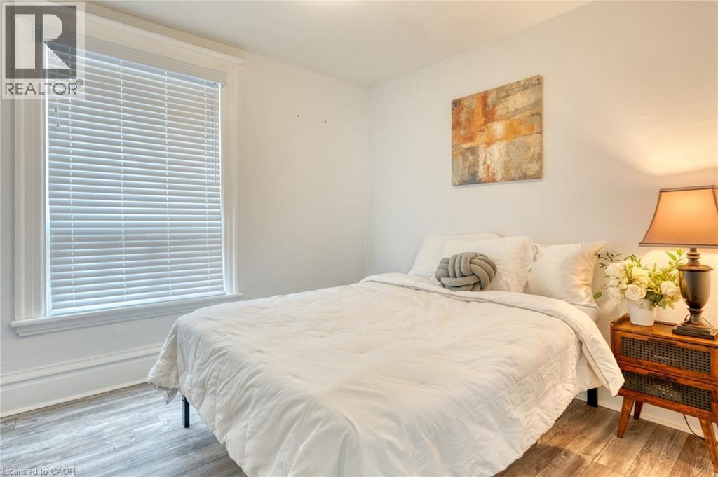 A bedroom with a large bed and a wooden nightstand.