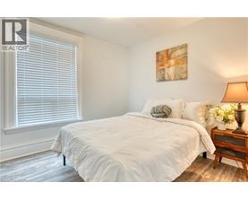 A bedroom with a large bed and a wooden nightstand.