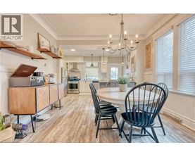 A modern kitchen with a wooden floor and a dining table set with chairs.