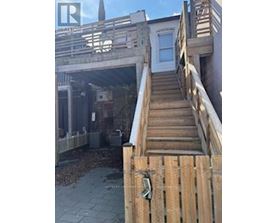 A wooden staircase leading to a house entrance.