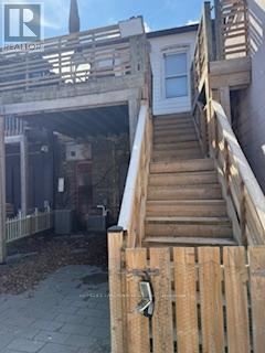 A wooden staircase leading to a house entrance.
