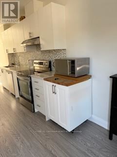 A kitchen with white cabinets and a wooden countertop.