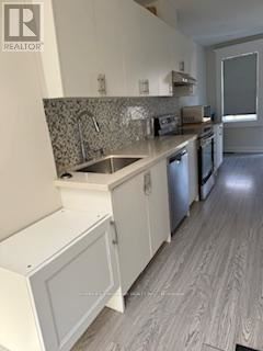 A kitchen with a sink and a dishwasher.