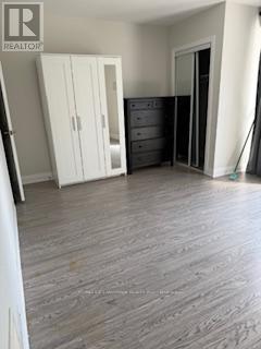 A bedroom with a wooden floor and a white wardrobe.