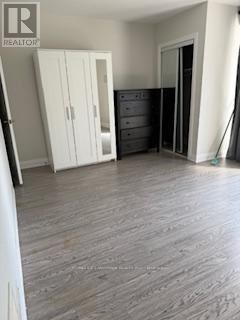 A bedroom with a wooden floor and a white wardrobe.