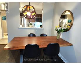 A dining room with a wooden table and chairs.