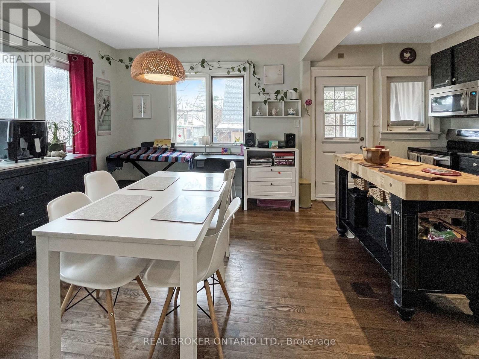 A well-lit kitchen with a dining table and chairs.