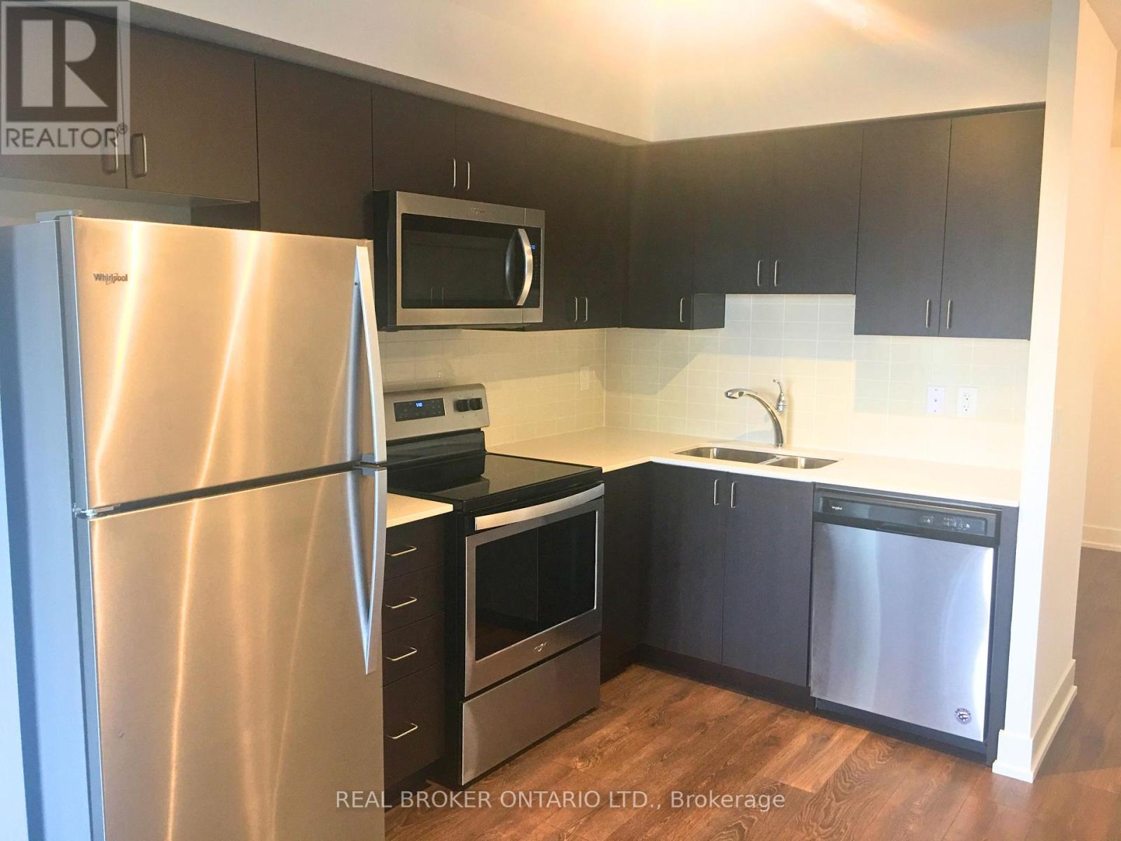 A kitchen with a stainless steel refrigerator, microwave, oven, and dishwasher.