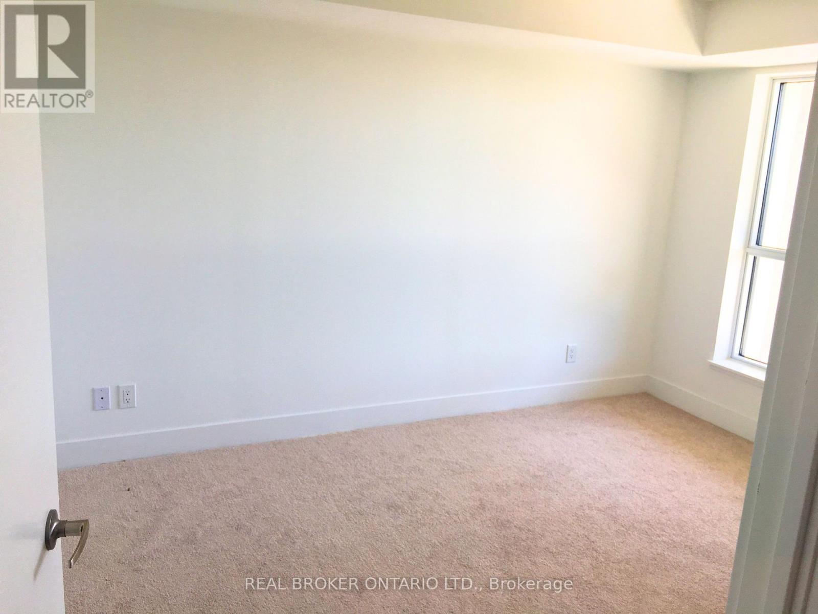 A room with beige carpet and white walls.