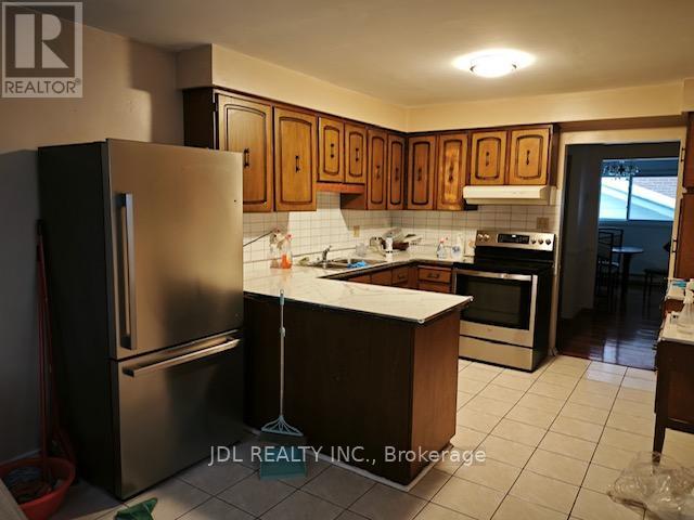 A kitchen with a refrigerator, sink, and oven.
