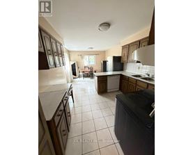 A kitchen with a refrigerator, sink, and oven.