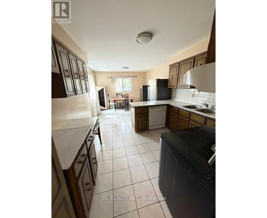 A kitchen with a refrigerator, sink, and oven.