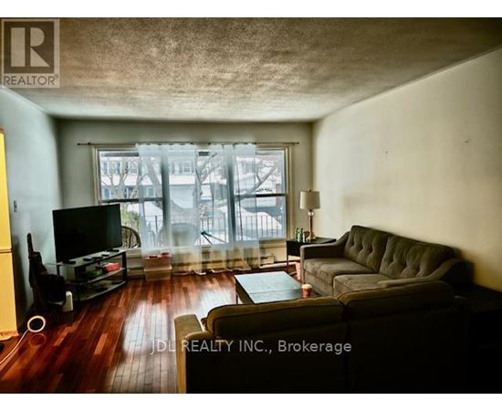 A living room with a grey couch and a television.