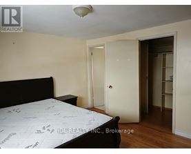 A bedroom with a bed, dresser, and closet.