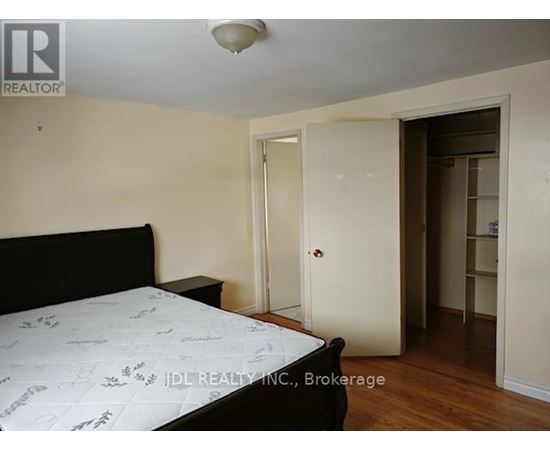 A bedroom with a bed, dresser, and closet.