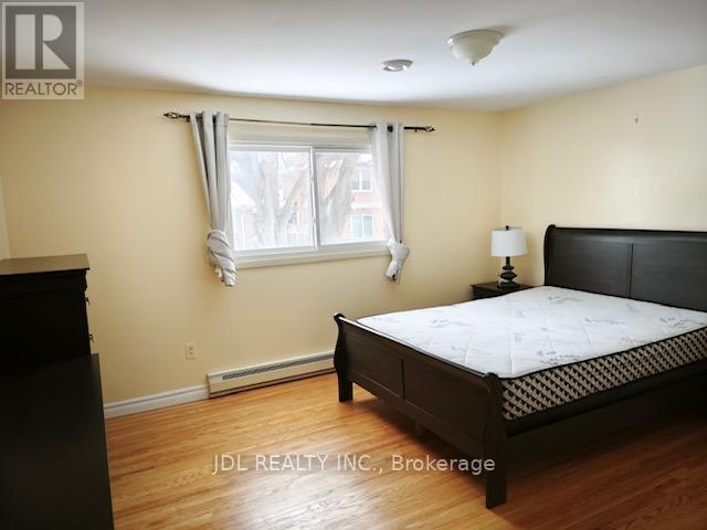 A bedroom with a bed, nightstand, and window.