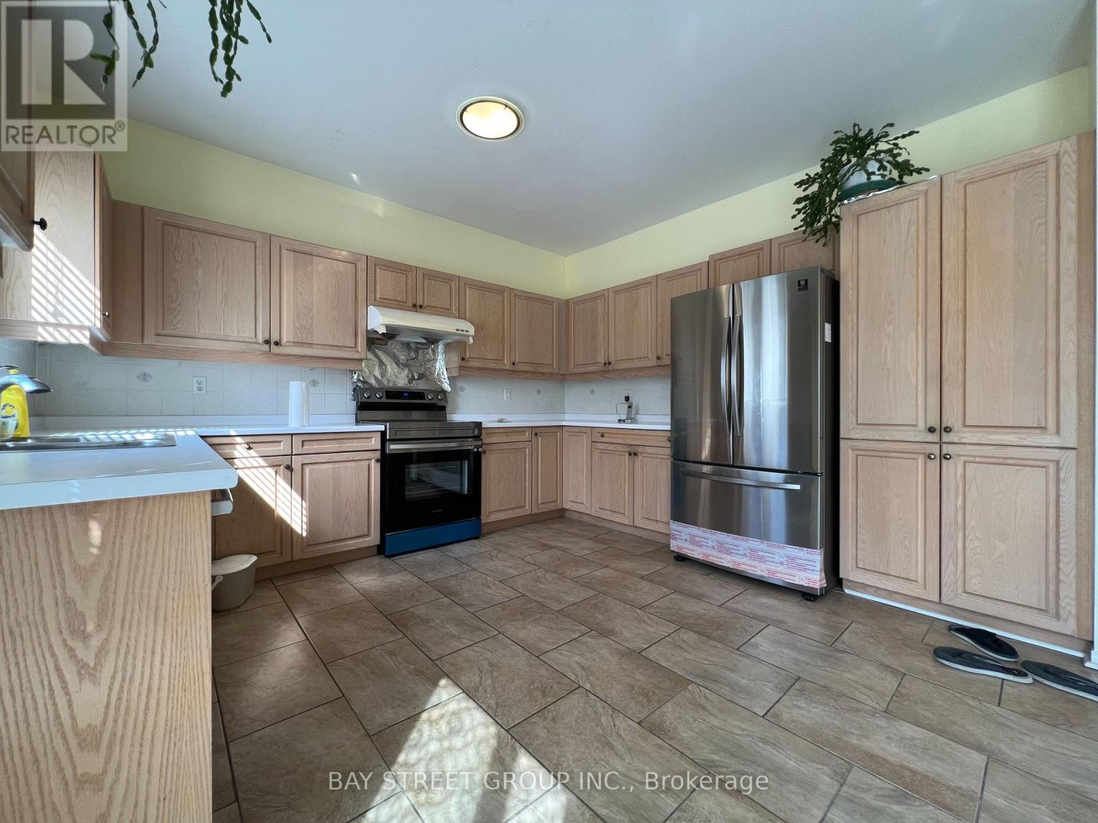 A kitchen with wooden cabinets and a refrigerator.
