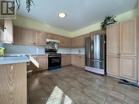 A kitchen with wooden cabinets and a refrigerator.