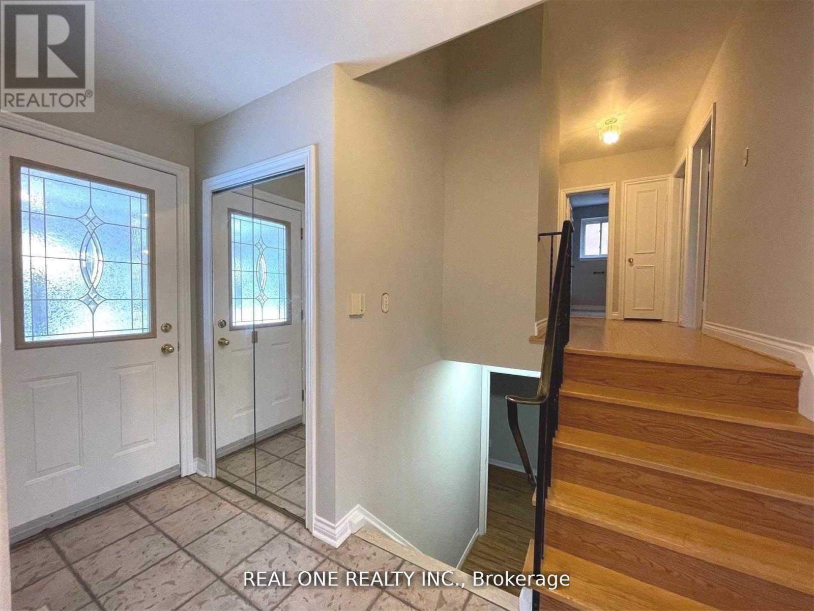 A hallway with a staircase leading to the second floor.