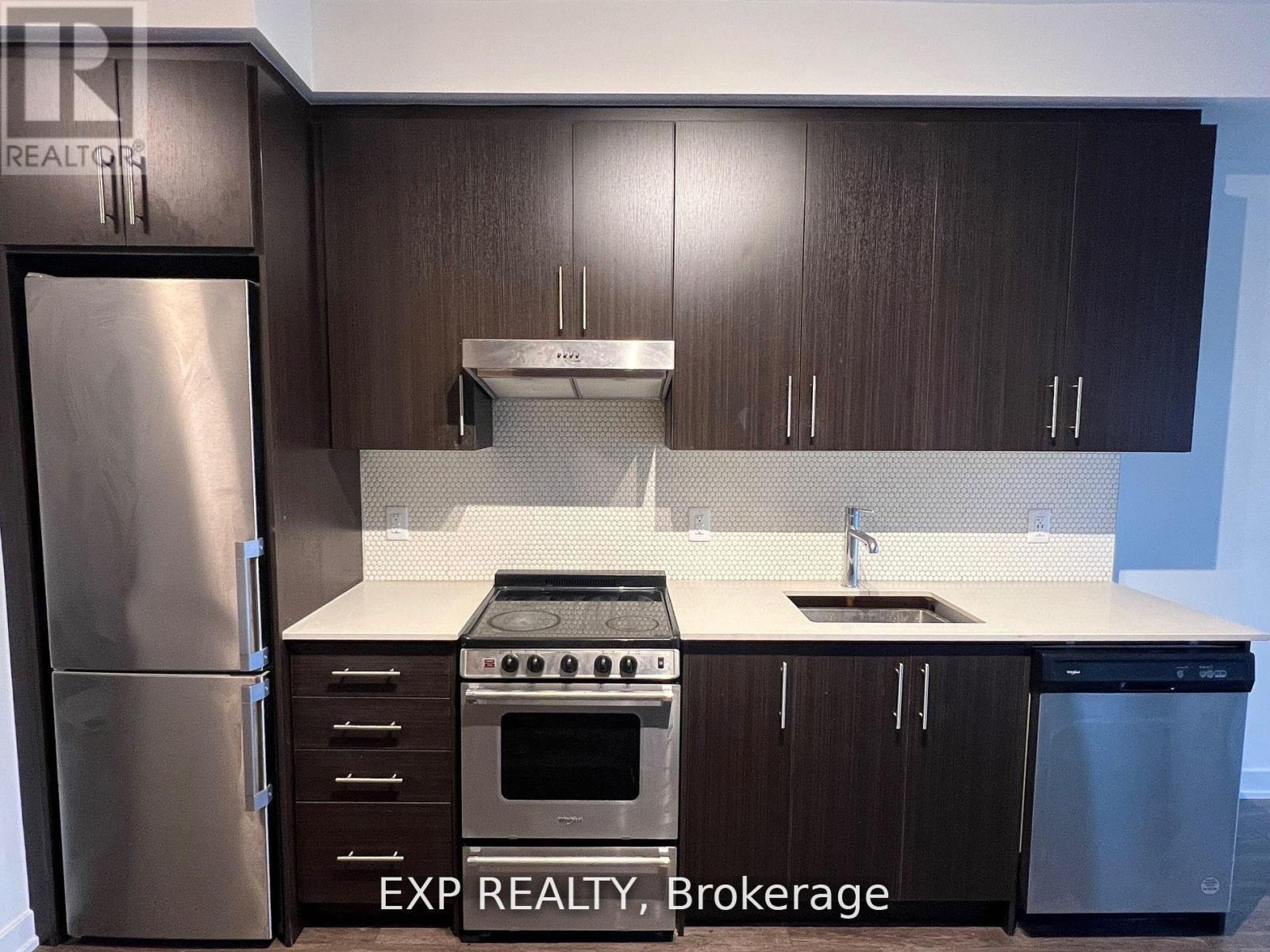 A kitchen with dark wood cabinets and stainless steel appliances.