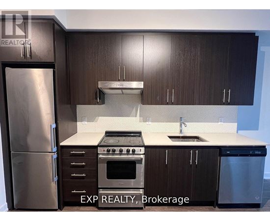 A kitchen with dark wood cabinets and stainless steel appliances.