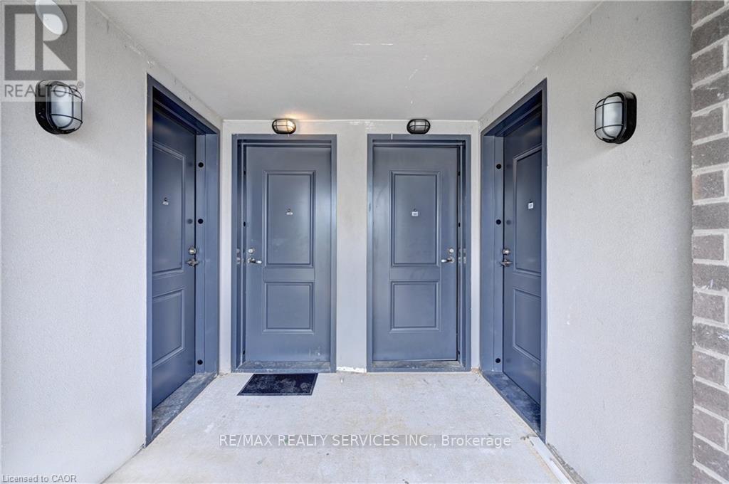 Three doors are closed and have a mat in front of them.
