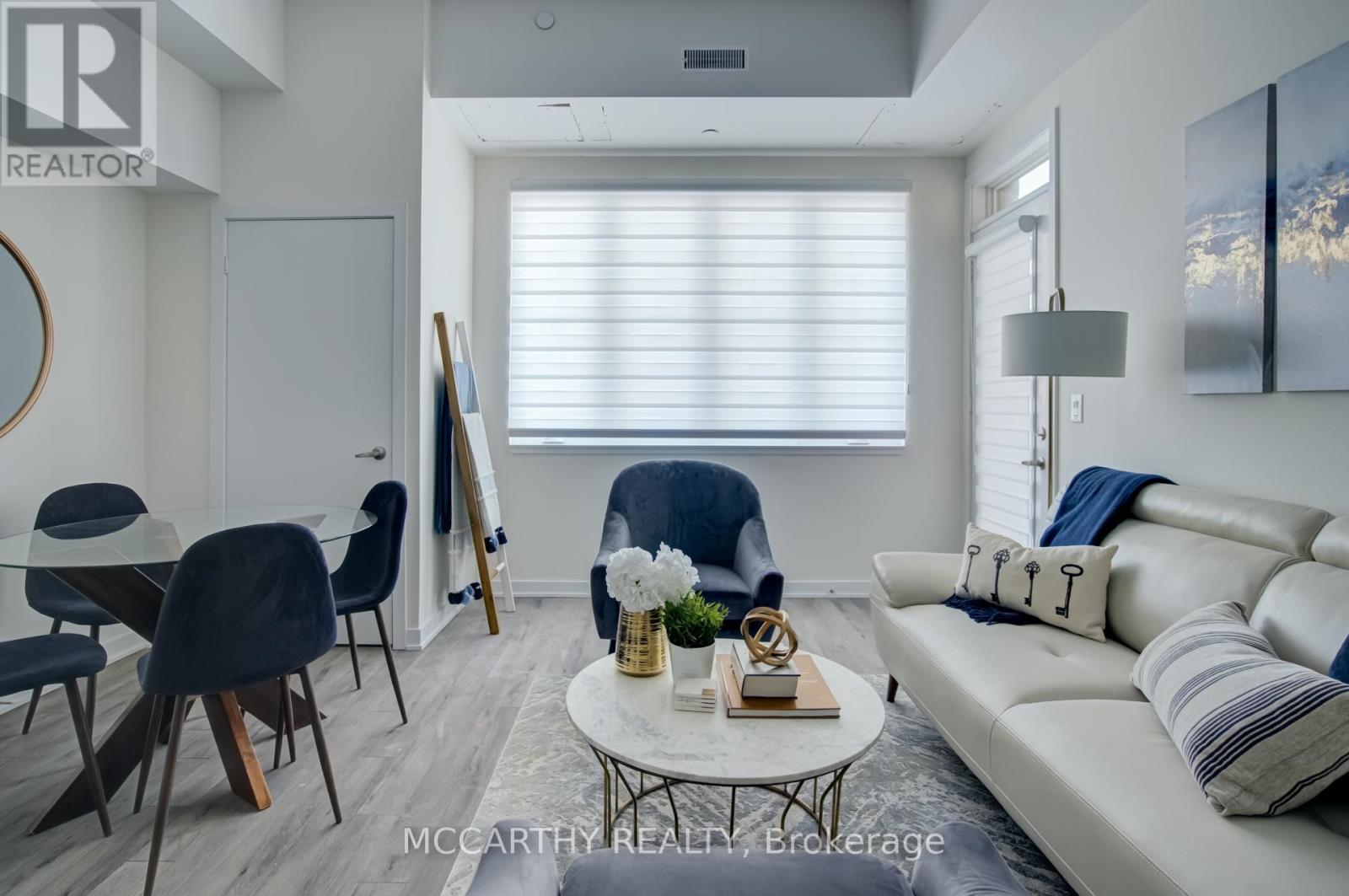 A living room with a white couch, a coffee table, and a painting on the wall.