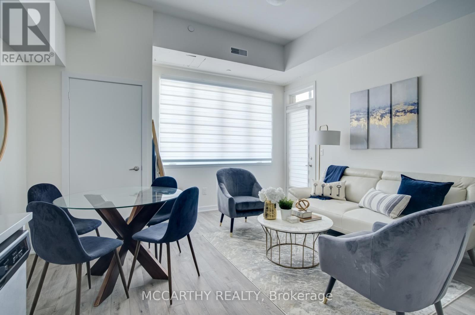 A modern dining room with a glass table and chairs.