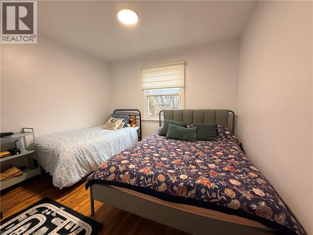 A bedroom with a floral bedspread and a window with blinds.
