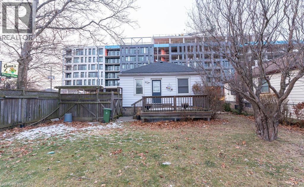 A house with a fence and a tree in front of a building.