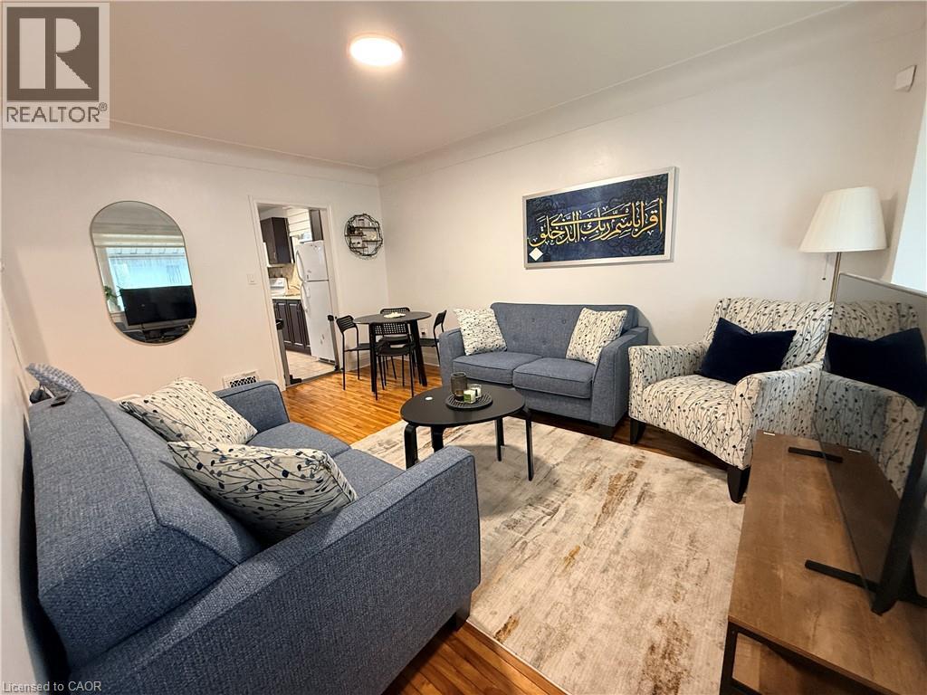 A living room with a grey couch and a wooden floor.