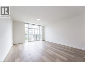 A spacious room with wooden flooring and a sliding glass door.