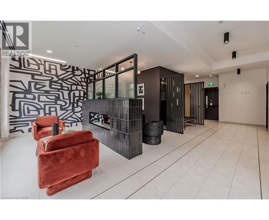 A living room with a red chair and a black and white patterned wall.
