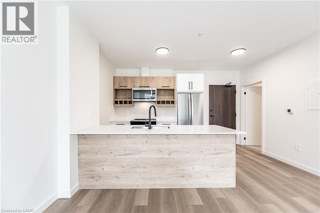 A modern kitchen with a wooden island and stainless steel appliances.