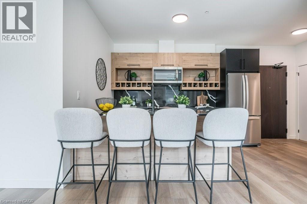 A modern kitchen with white chairs and a wooden counter.