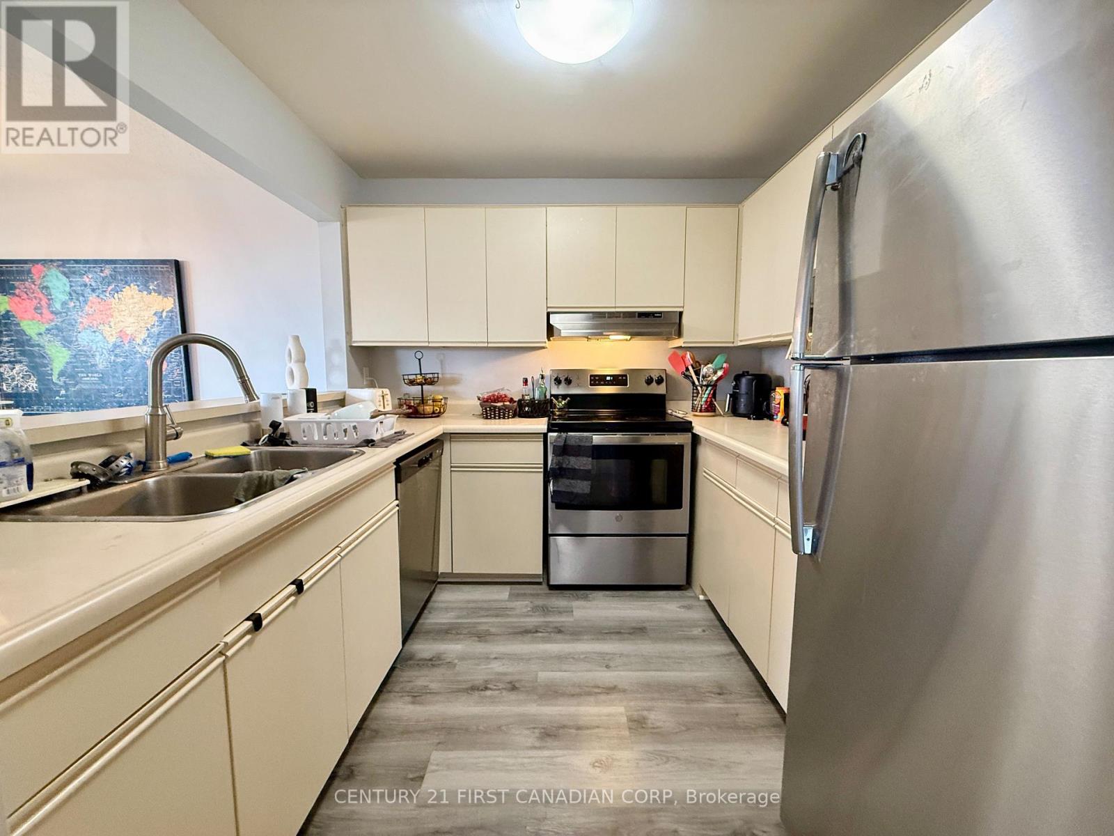 A kitchen with a stainless steel refrigerator and a stove top oven.