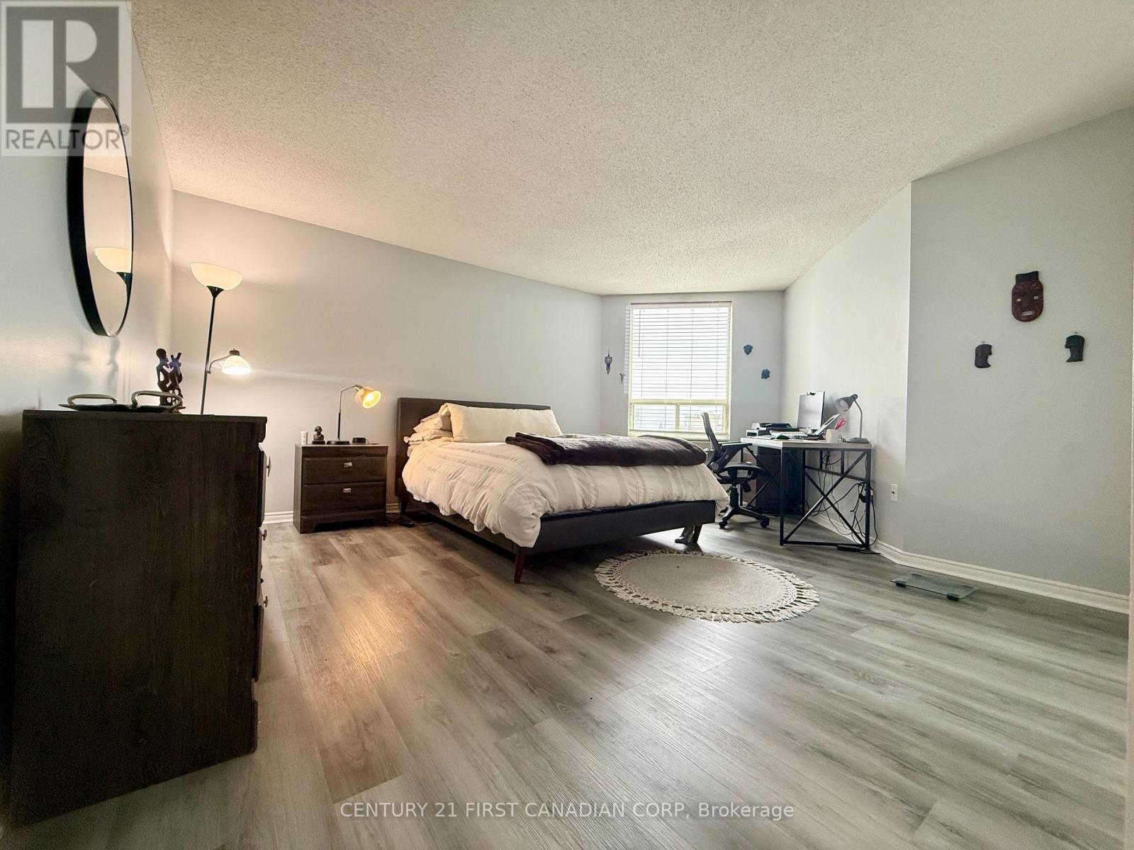 A bedroom with a bed, desk, and chair.