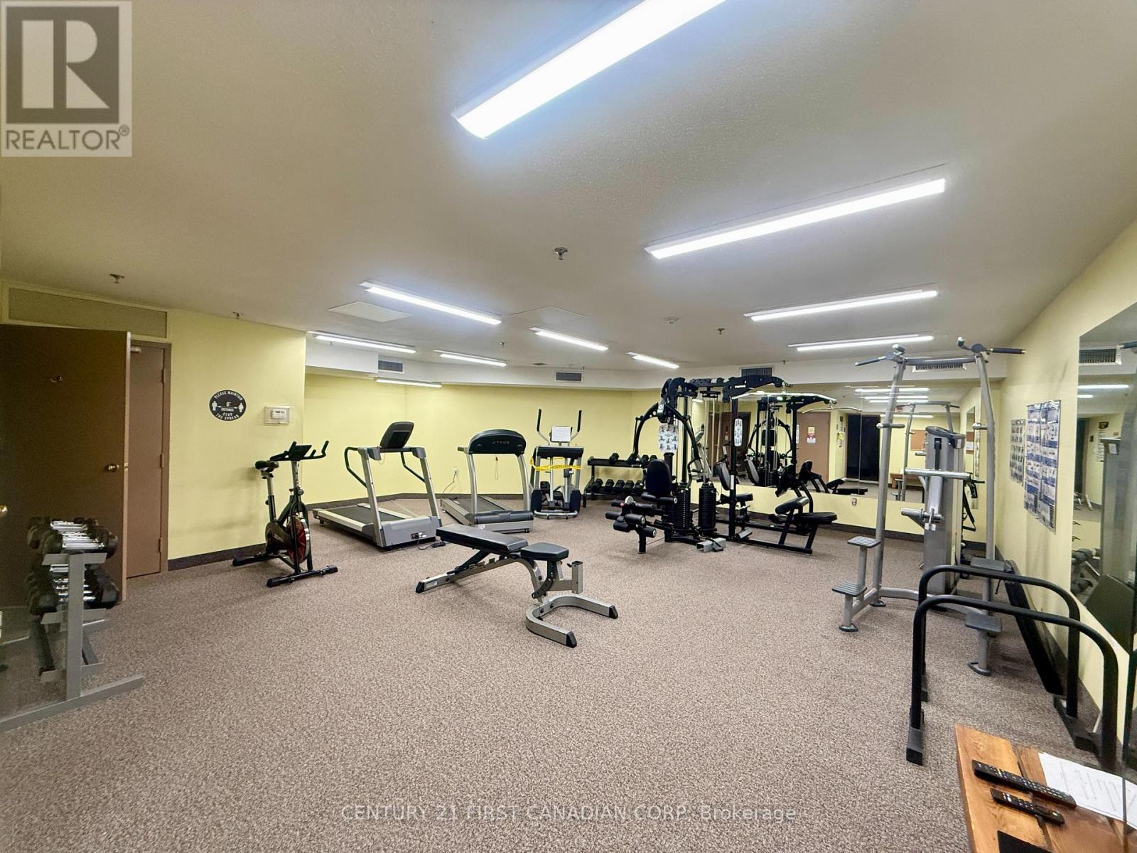A gym with a variety of equipment including treadmills, weights, and exercise machines.