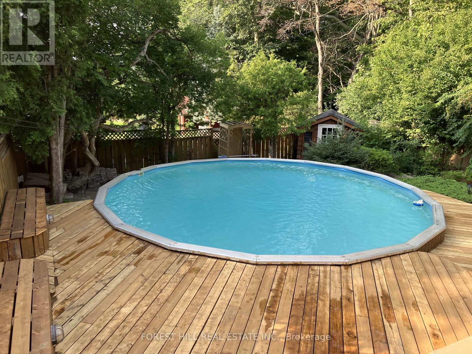 A wooden deck surrounds a small in-ground pool.