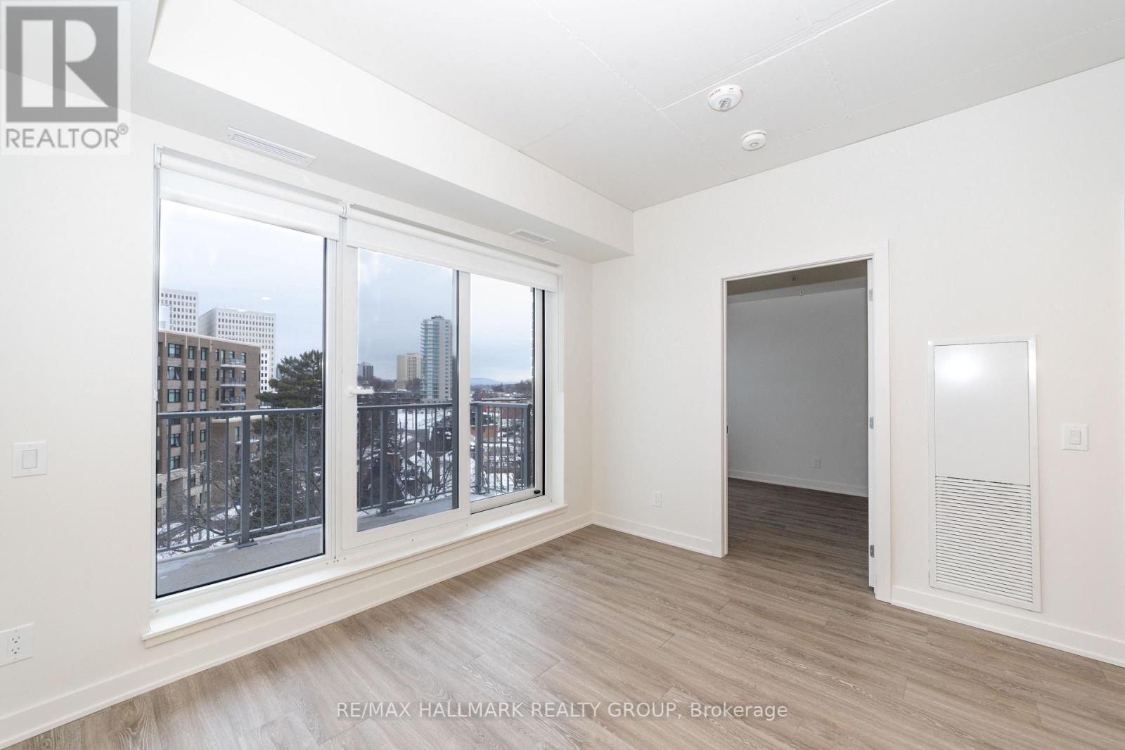 A spacious room with a view of the city through large windows.