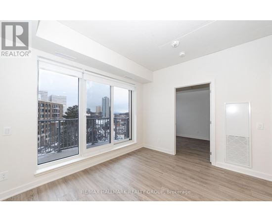 A spacious room with a view of the city through large windows.