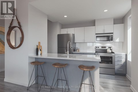 A modern kitchen with a bar area and a large mirror on the wall.